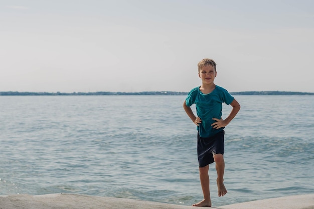 Boy blond smile fun expression bright sun charming nature sport sea beach wet summer