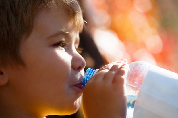 Boy bottle of water. Young boy holding drink fresh water bottle.