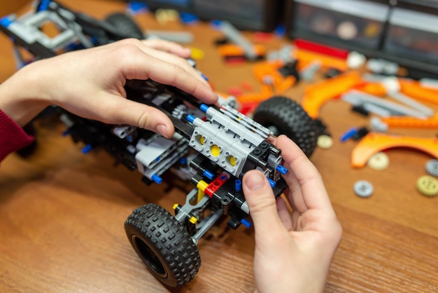 Boy building robot car with electronic constructor Boy learning basics of engineering by playing with modern technological constructor