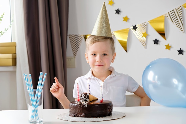 Boy celebrating birthday blowing lighting candles on a cake