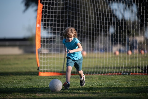 Boy child kicking football on the sports field during soccer match boy kicking football on the field