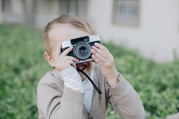 Boy child look at viewfinder of analogue film vintage photo camera