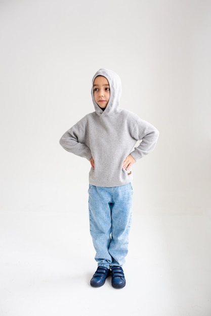 Boy child preschooler smiling and posing on gray background in photo studio