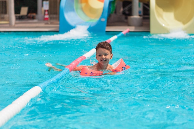 A boy a child in sleeves swimming in the pool cute kid himself swims in the pool rest and relax