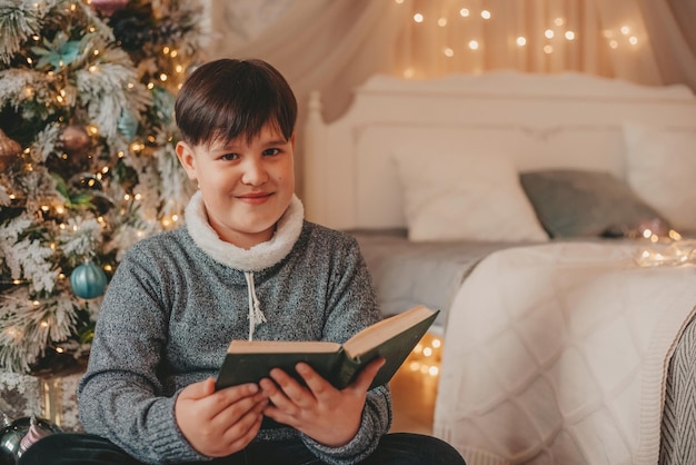 boy in christmas decorations reading book