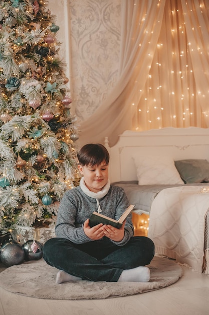 boy in christmas decorations reading book