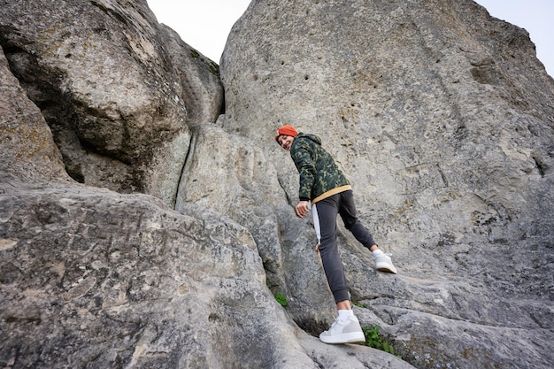 Boy climbing big stone in hill Pidkamin Ukraine