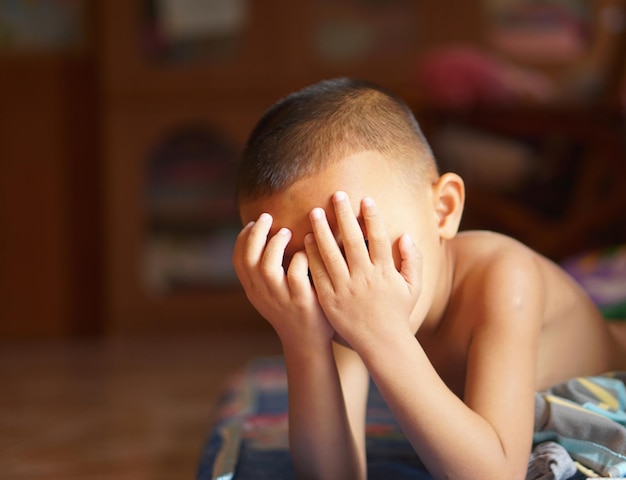 The boy covered his eyes with his hands to block the sun