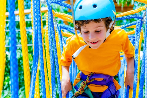 Boy crossing course high ropes element in adventure park outdoor concept climbing extreme sport phys