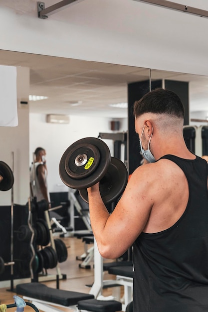 Boy doing exercise in front mirror while wears a mask