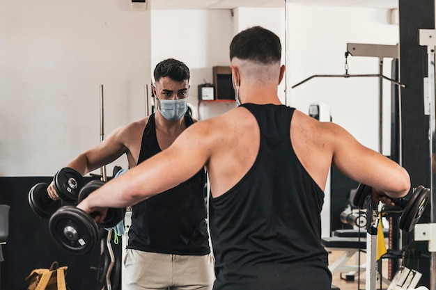 Boy doing exercise in front mirror while wears a mask