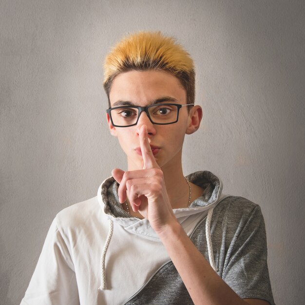 Boy doing the gesture of silencing