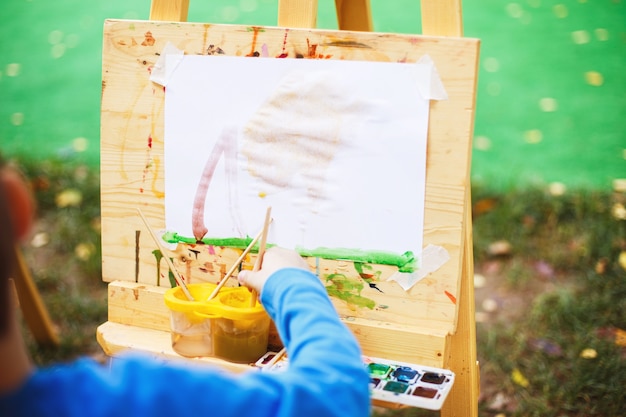 Boy draws  on the easel