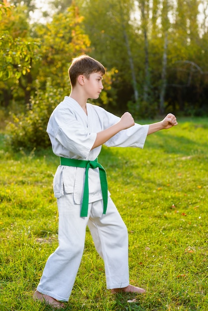 boy dressed kimono doing karate exercises