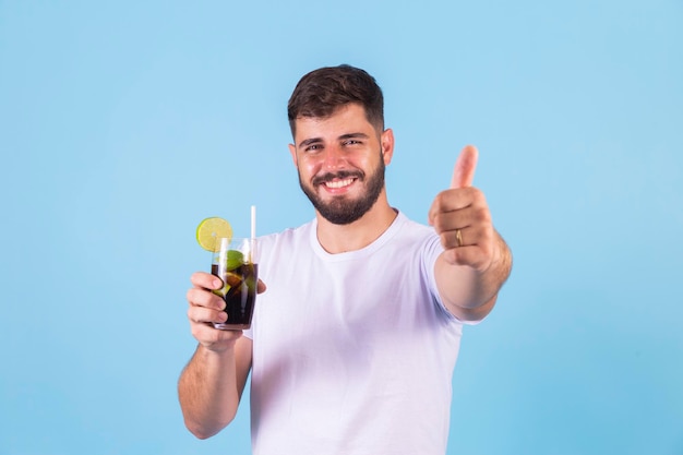 Boy drinking a cola soda raises thumb up