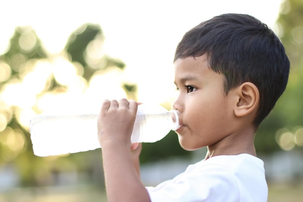 Boy drinking water from a bottle outdoors