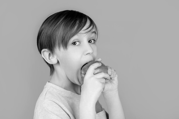 Boy eating apple and smiling Boy smiles and has healthy white teeth Little boy eating apple Boy apples showing Child with apples Black and white