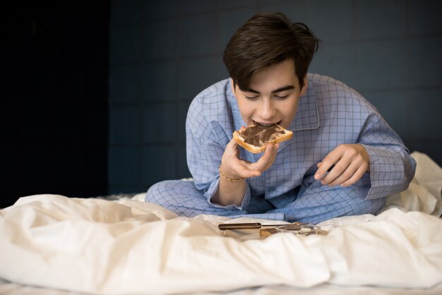 Boy Eating Crunchy Toast in Bed