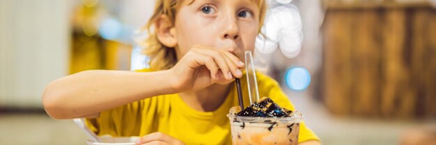 Boy eating ice cream in a cafe banner long format