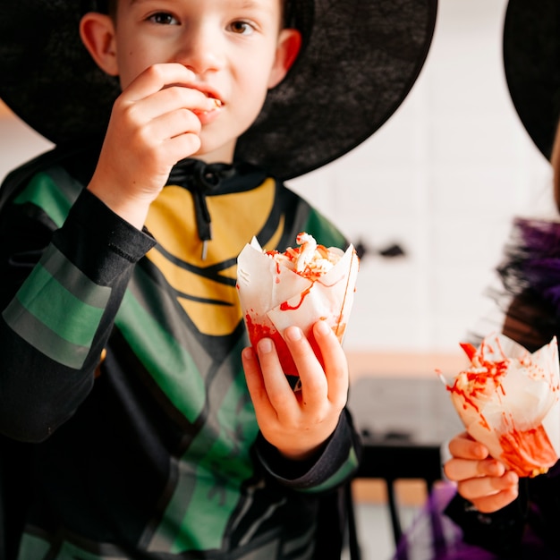 A boy eating sweets at a Halloween party