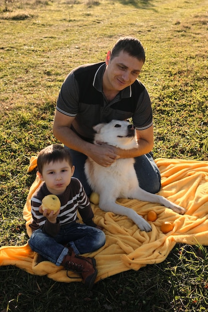 Boy eats an apple Young happy Caucasian family has fun together in nature