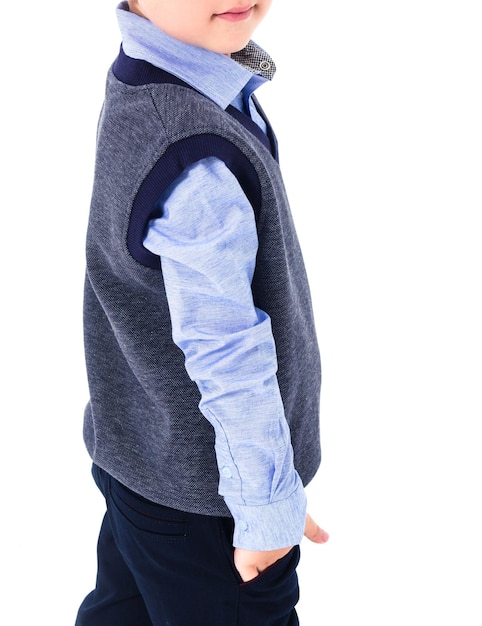 Boy elementary school student posing in school uniform The boy is wearing a blue shirt and vest Vertical photo