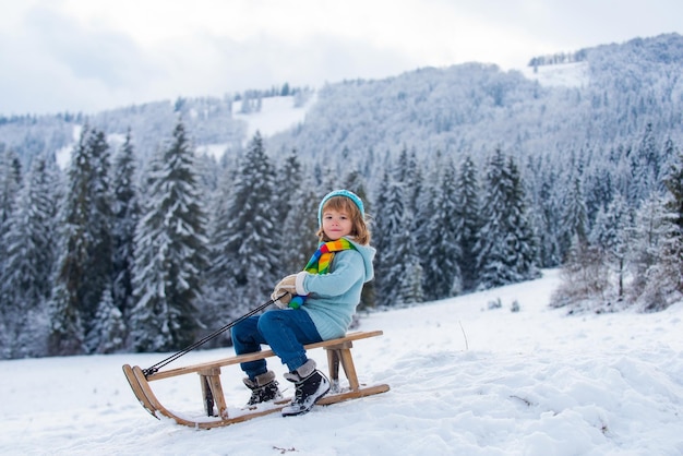 Boy enjoy a sleigh ride child sledding riding a sledge children play in snow in winter outdoor kids