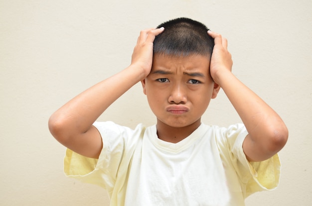 Boy feeling sad and frustrated with his hand on his head