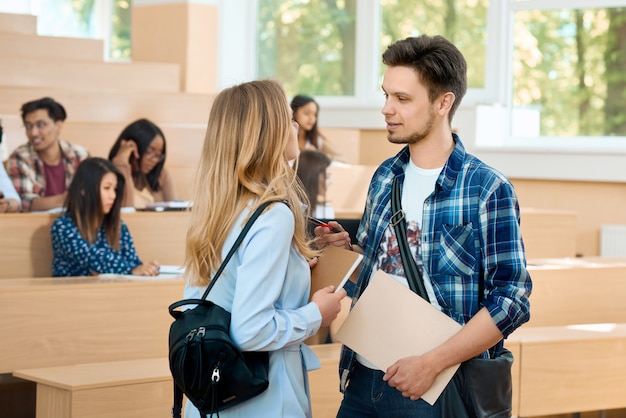 Boy and girl communicating in university.