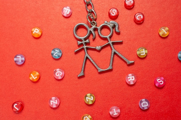 Boy and girl icon made of wire on red among the colorful abc alphabet letters