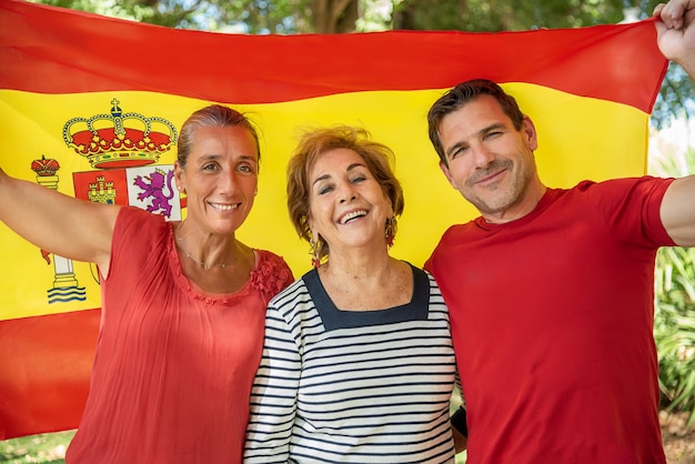 A boy and girl next to an older lady raising the flag of Spain Proud to be Spanish Long live Spain