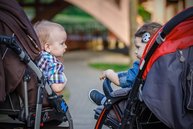 boy and girl sitting in baby carriages