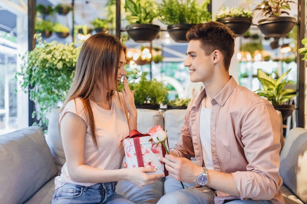 Boy gives the beautiful girl a rose and a surprise