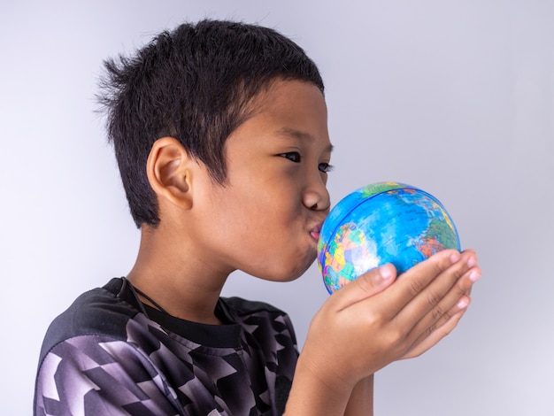 A boy hands the globe and kisses it on the globe Show the power of the new generation to continue to develop our world