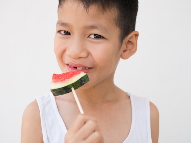 Boy happy when eat water melon.