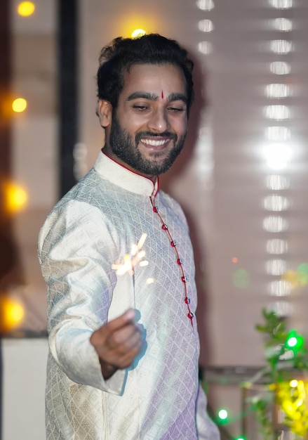 A boy A having sparkler to celebrate diwali and wearing traditional dress