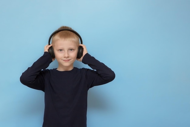 Boy in headphones on a blue background background with copy space