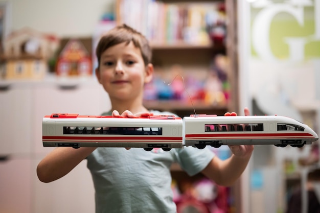 Boy hold toy high speed train in hands at children's room