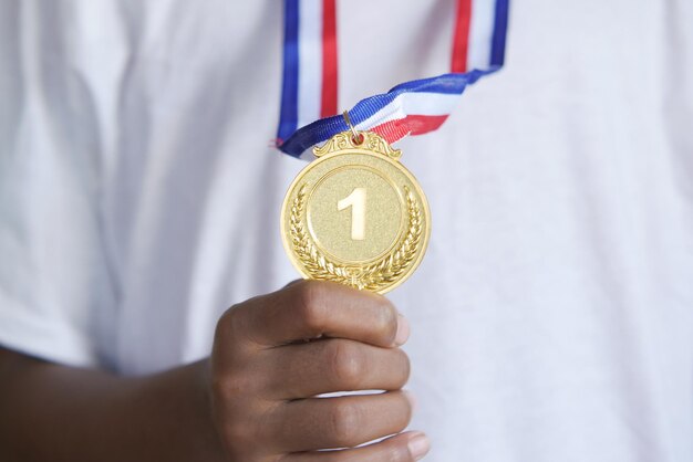 Boy holding first place throphy against yellow background