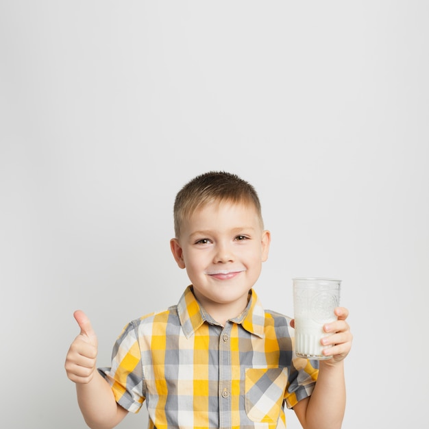 Boy holding glass of milk in hand