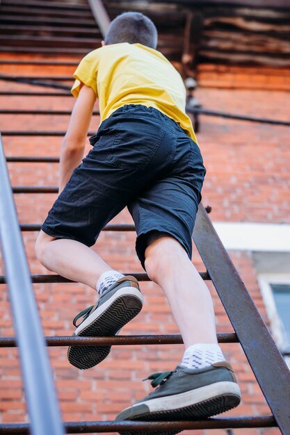 Boy is climbing a high staircase