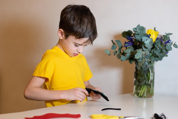 the boy is doing needlework Sewing a soft toy from felt hands closeup Pastime at home