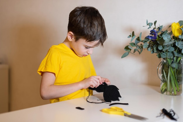 the boy is doing needlework Sewing a soft toy from felt hands closeup Pastime at home