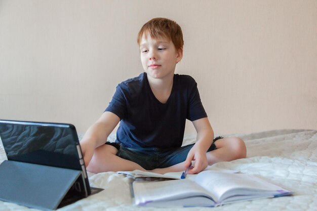 the boy is engaged on a laptop at home children education concept