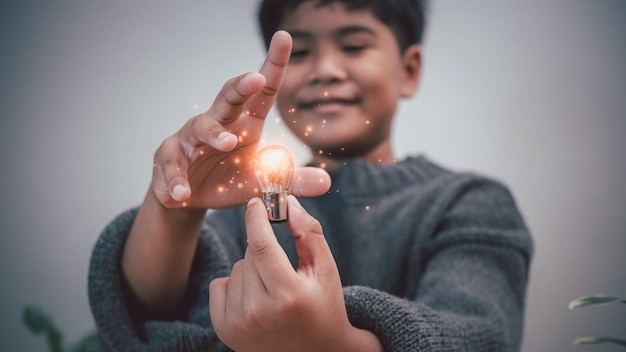 The boy is holding a light bulb It represents the concept of education learning innovation and success