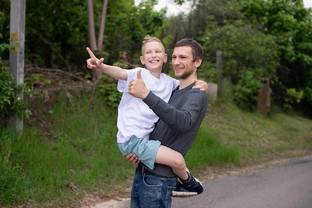 The boy is sitting in Dad's arms and they are laughing