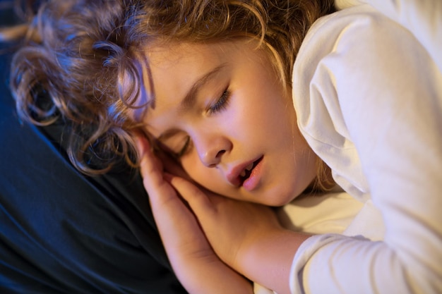 Boy is sleeping on the bed with his mouth open snoring Kid sleeps face close up Child sleep napping Cute kid sleeping in bed Sleeping kid face