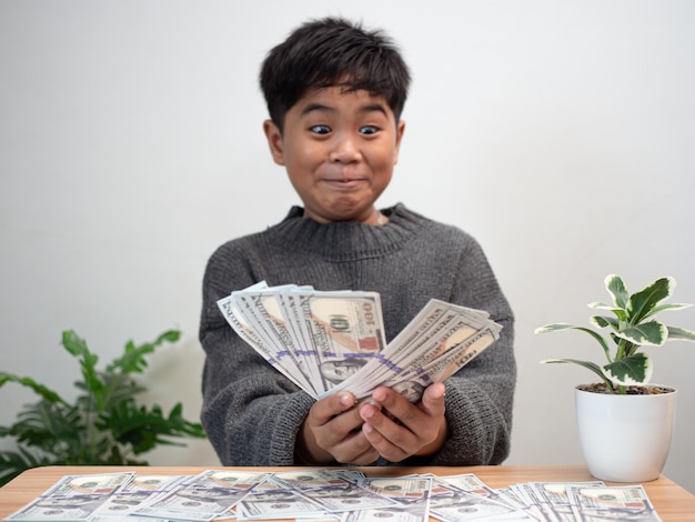 The boy joyfully holds the money Money saving concept investment finance