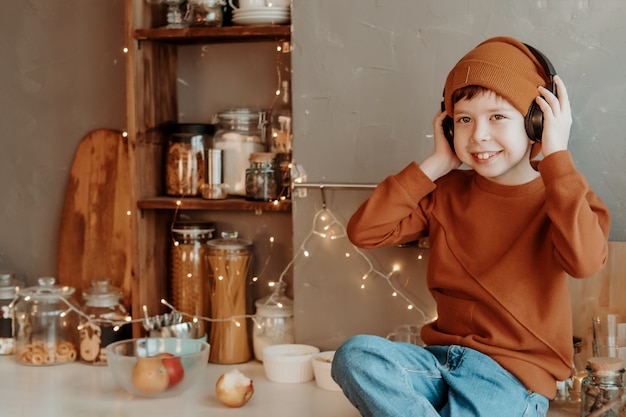 Boy in the kitchen listening to music through wireless headphones.