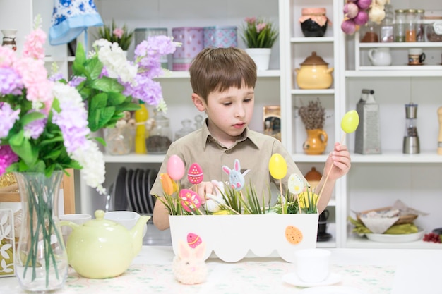 Boy in the kitchen playing with easter eggs